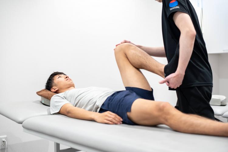 アスレティックトレーナーがストレッチを実施している