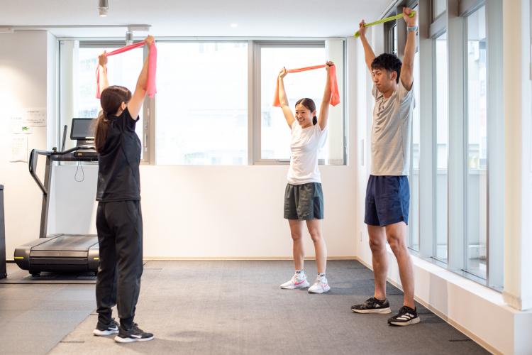 チューブトレーニングを指導するアスレティックトレーナー