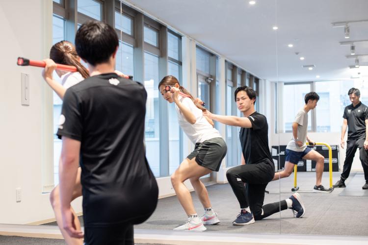 スクワットの指導をするアスレティックトレーナー